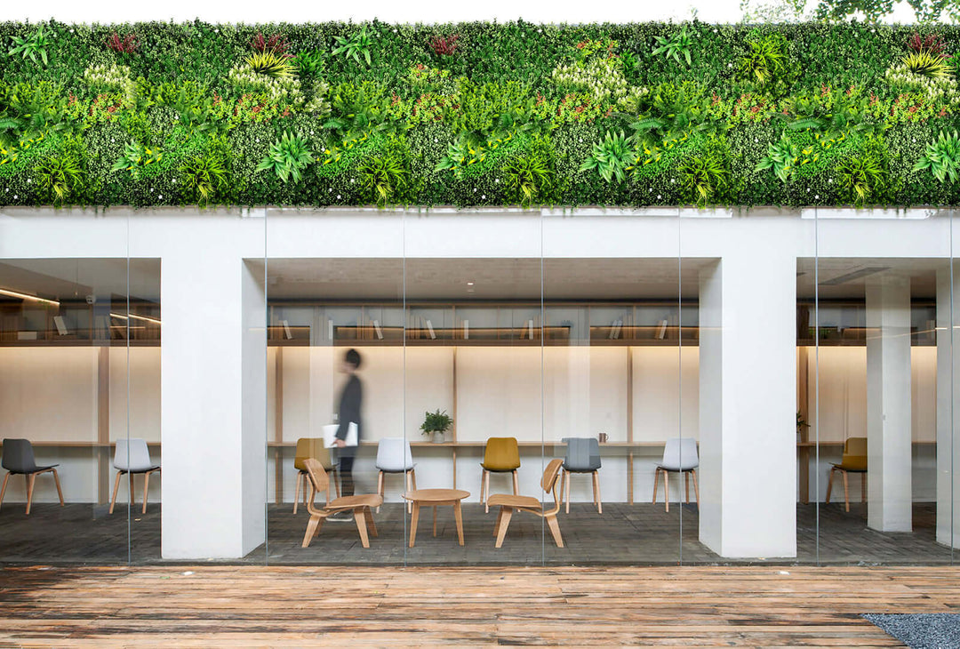 Modern workspace featuring a lush vertical garden wall, transparent partitions, and stylish wooden chairs.