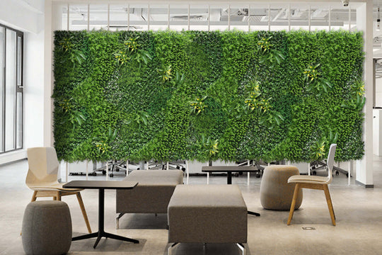 Lush green artificial plant wall decor in modern office, enhancing ambiance with affordable DIY vertical garden design.