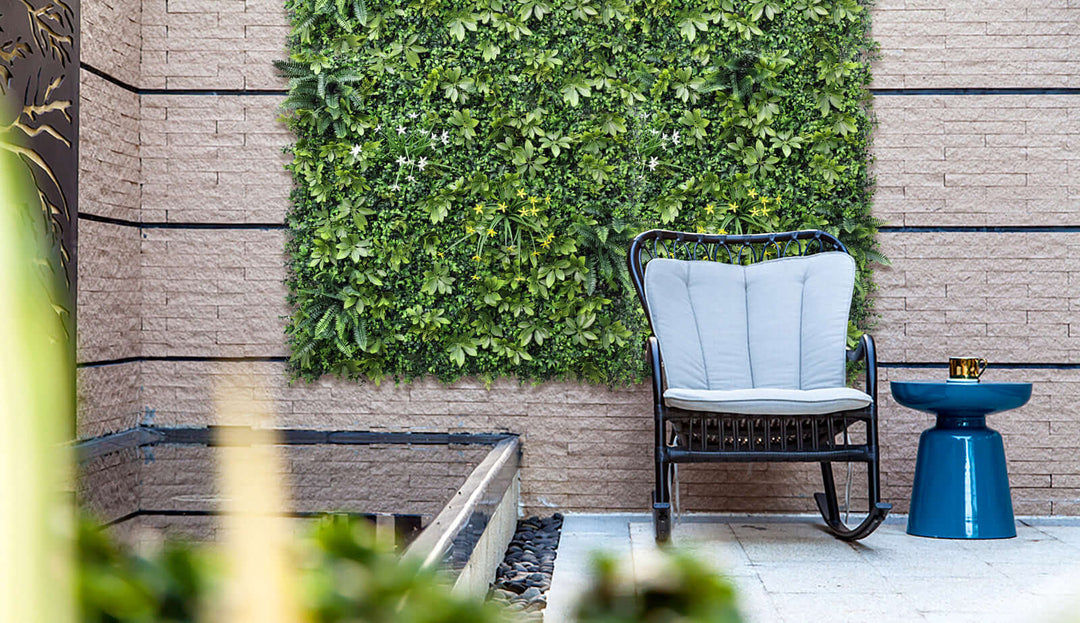 Elegant vertical garden with lush artificial grass panel behind a stylish chair and table in a modern outdoor space.