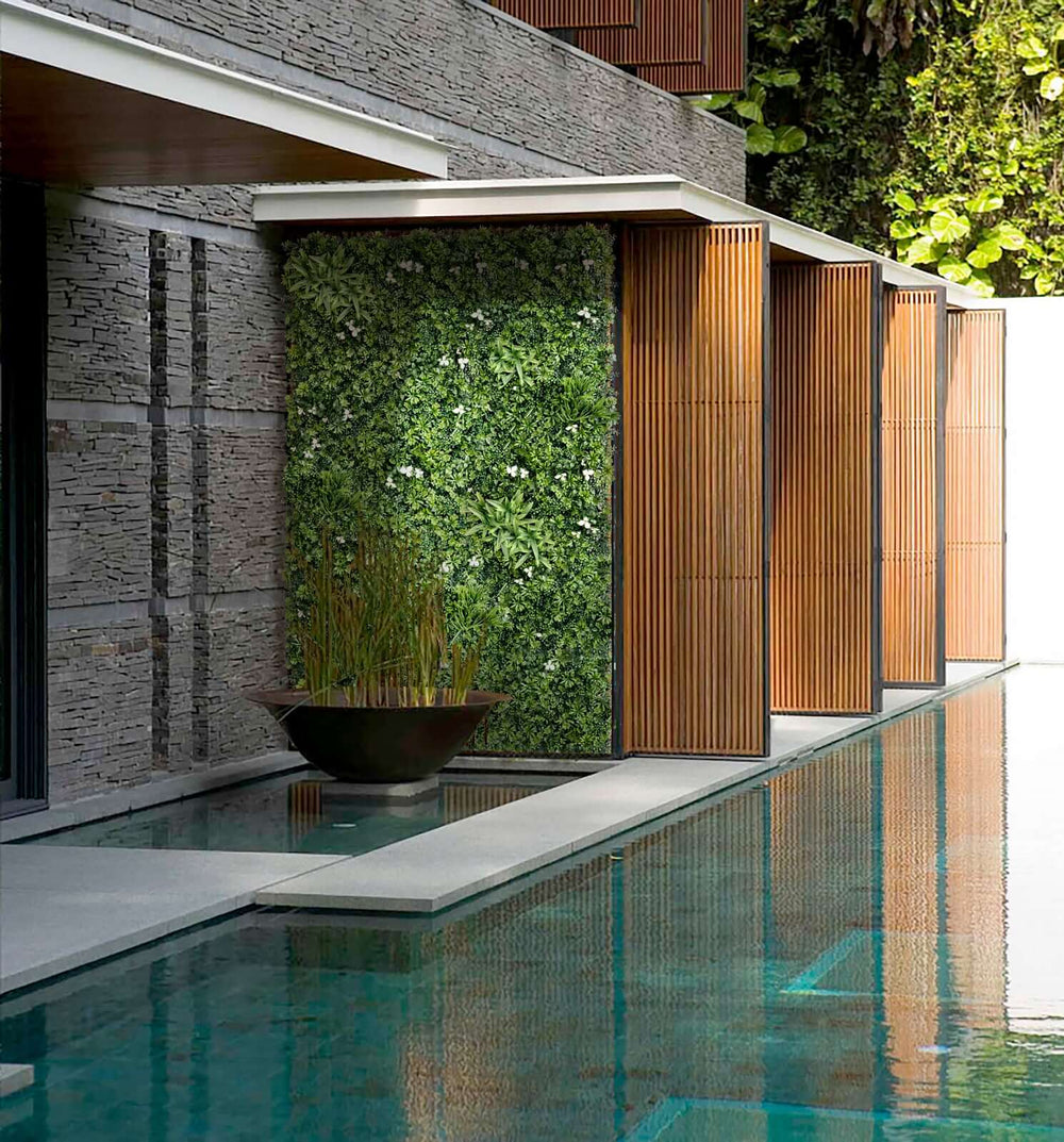 Lush green artificial plant wall panels enhance modern architecture near a tranquil pool. Affordable DIY vertical garden design.