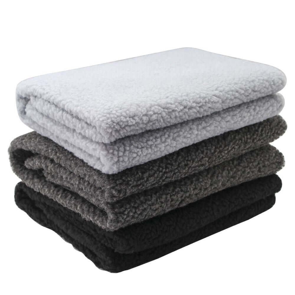 Folded fleece pet blankets in gray and black, perfect for dogs and cats, offering softness and warmth.