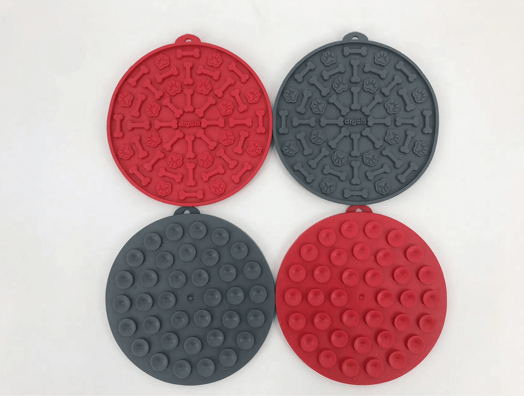 Set of four silicone pet treat mats in red and grey with various textures for dog and cat use.