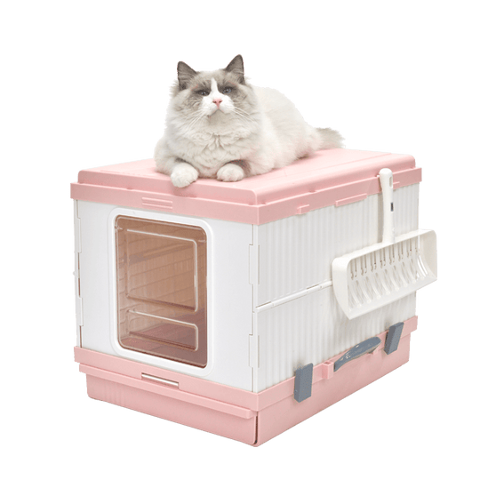 Pink XL portable cat toilet litter box with a fluffy cat resting on top, featuring a scoop and hooded design for odor control.