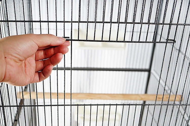 Close-up of a hand adjusting a latch inside the YES4PETS bird cage, showcasing its quality design features.