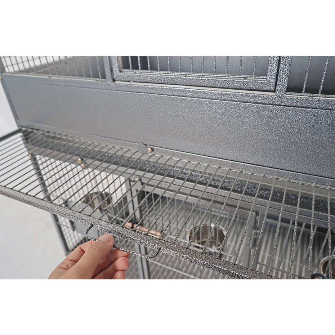 Hand adjusting the removable grate of YES4PETS triple stackers parrot cage for easy cleaning and access.