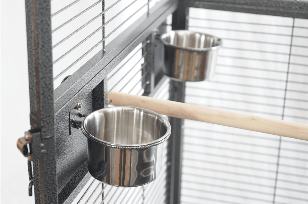 Interior view of YES4PETS bird cage featuring stainless steel food bowls and a wooden perch for pet comfort.