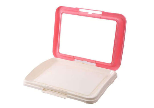 Portable dog potty training tray in pink and white, designed for easy waste removal and hygienic use.