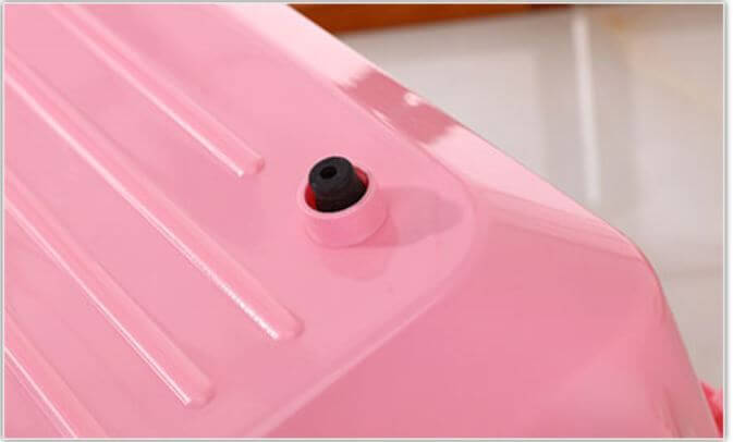 Close-up of pink pet carrier tray showing vent and waterproof design for small animals.