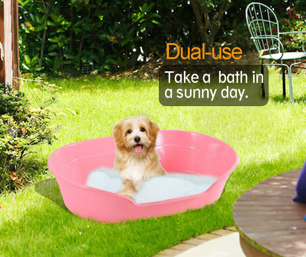 Small pink dog bed for bathing and lounging in sunny outdoor setting, showcasing durability and dual-use feature.