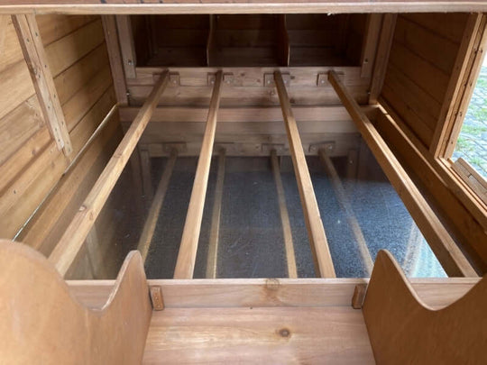 Interior view of YES4PETS chicken coop with spacious nesting area and wooden slats for easy access.