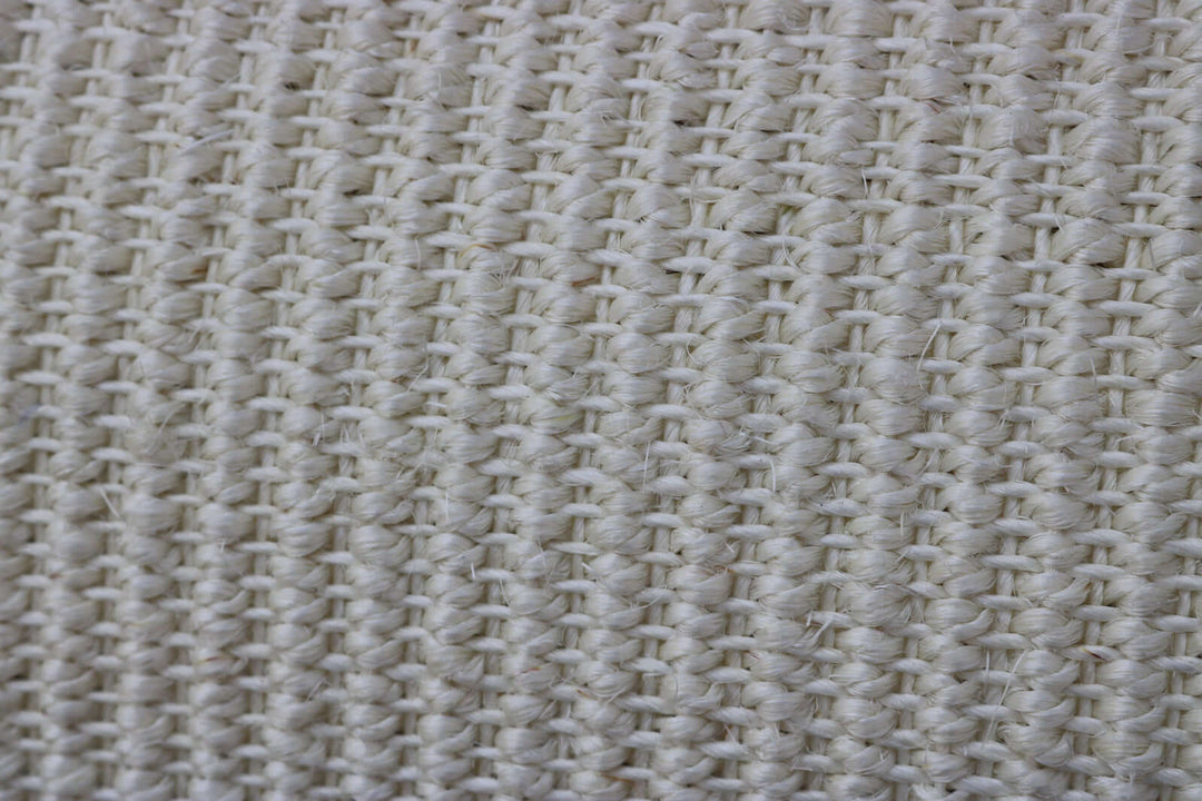 Close-up of woven, beige textile fabric with a textured surface, ideal for upholstery or décor.