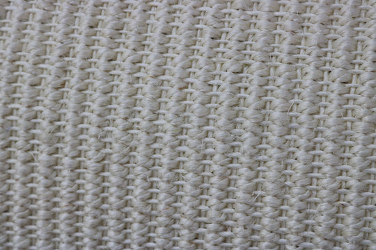 Close-up of woven, beige textile fabric with a textured surface, ideal for upholstery or décor.