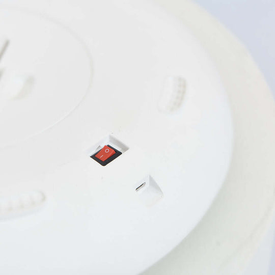 Close-up of power button and USB port on a white automatic pet feeder, showcasing its design and functionality.