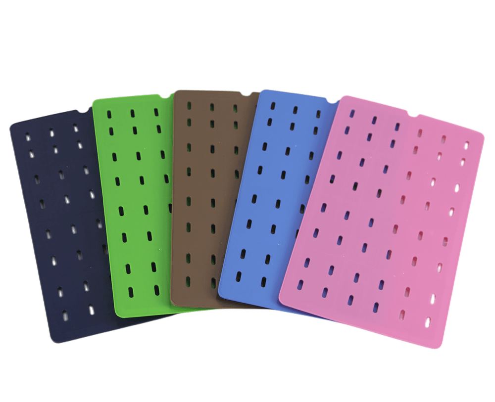 Colorful reusable plastic mats in blue, green, brown, black, and pink, featuring ventilation holes for easy cleaning.