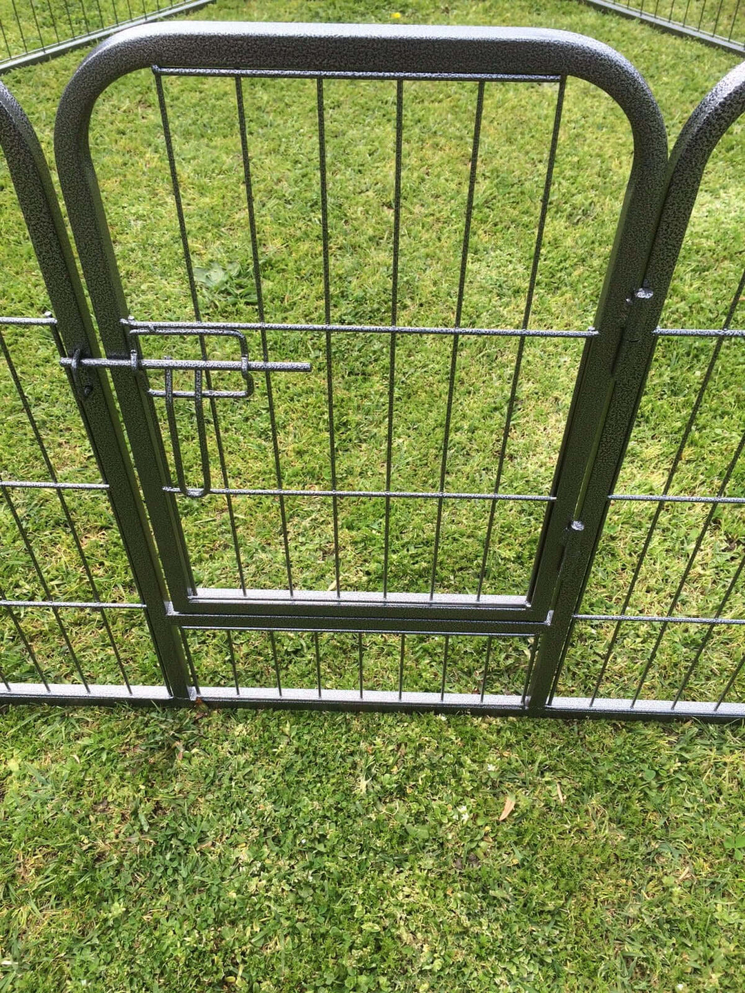 Heavy duty metal pet playpen gate on green grass, perfect for safe pet exercise and affordable pet containment.