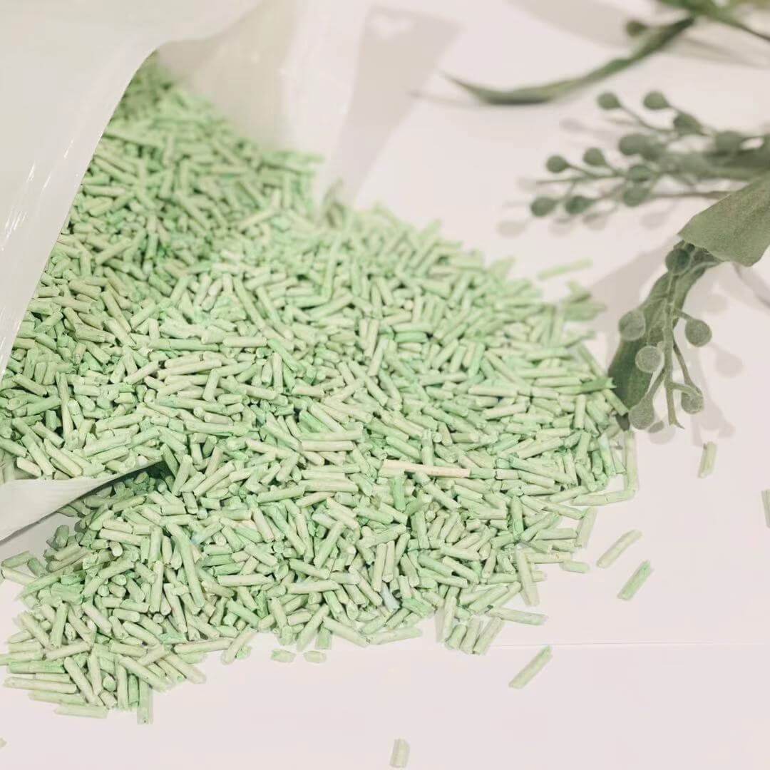 Green biodegradable tofu cat litter spilling from a bag, showcasing its eco-friendly and clumping properties.