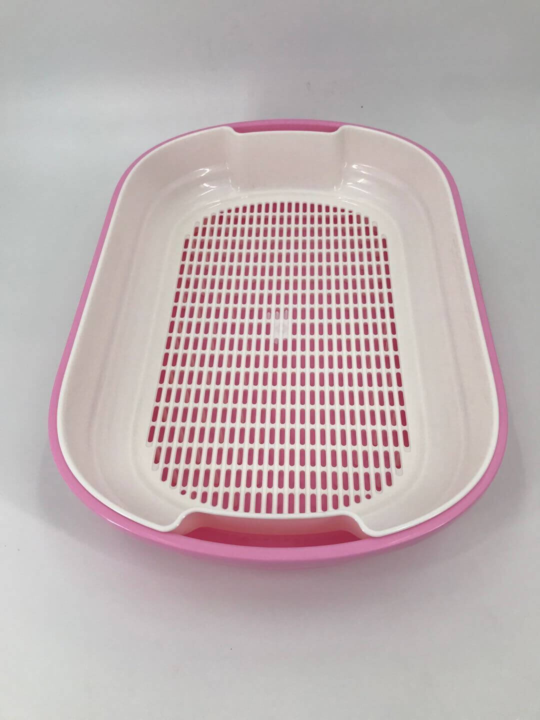 Pink portable cat litter tray with a grid design for easy waste removal and minimal mess.