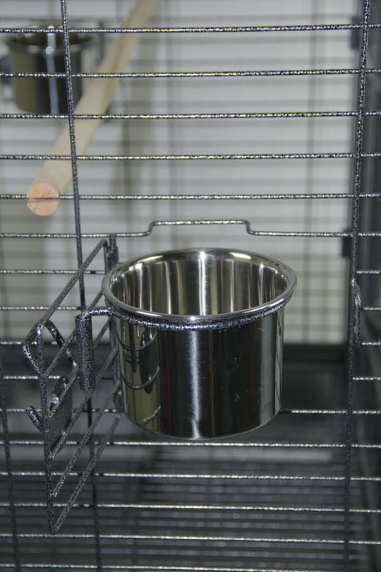 Stainless steel feeding bowl attached to a large bird cage, perfect for affordable and quality pet care.