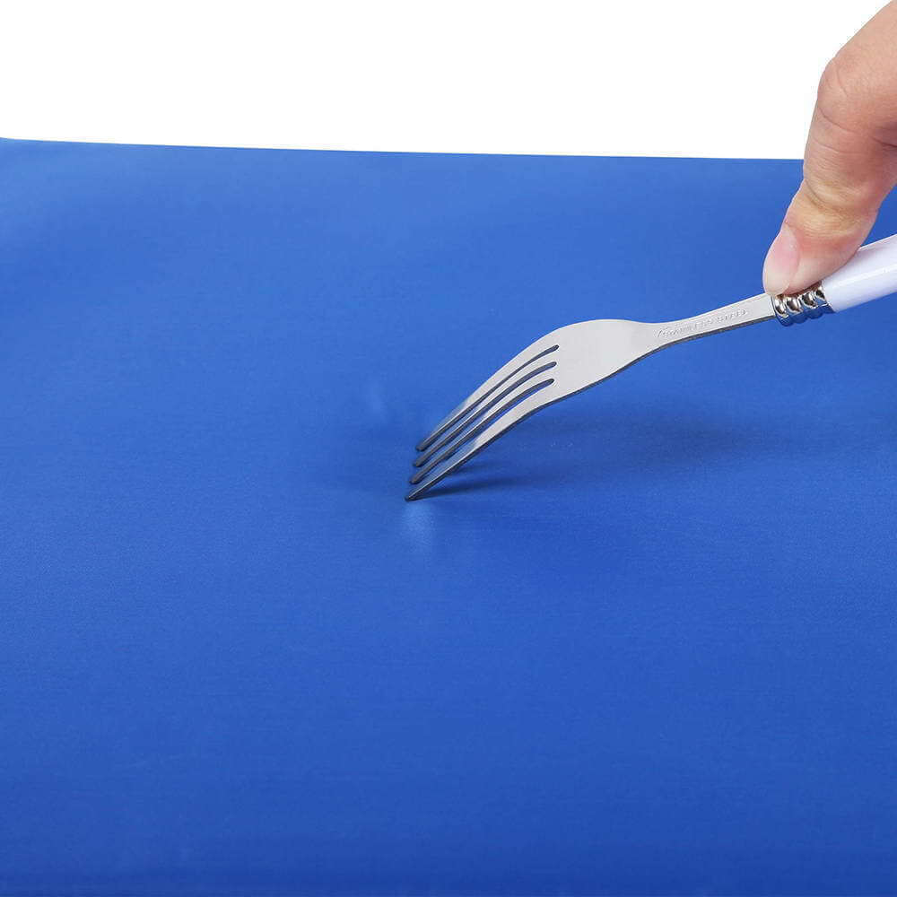 Person using a fork on a blue gel cooling mat for pets, demonstrating its soft and comfortable texture.