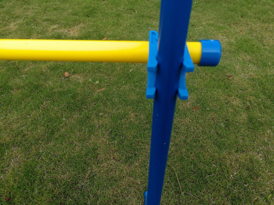 Close-up of a blue and yellow portable dog training jump bar on green grass, perfect for DIY agility training.