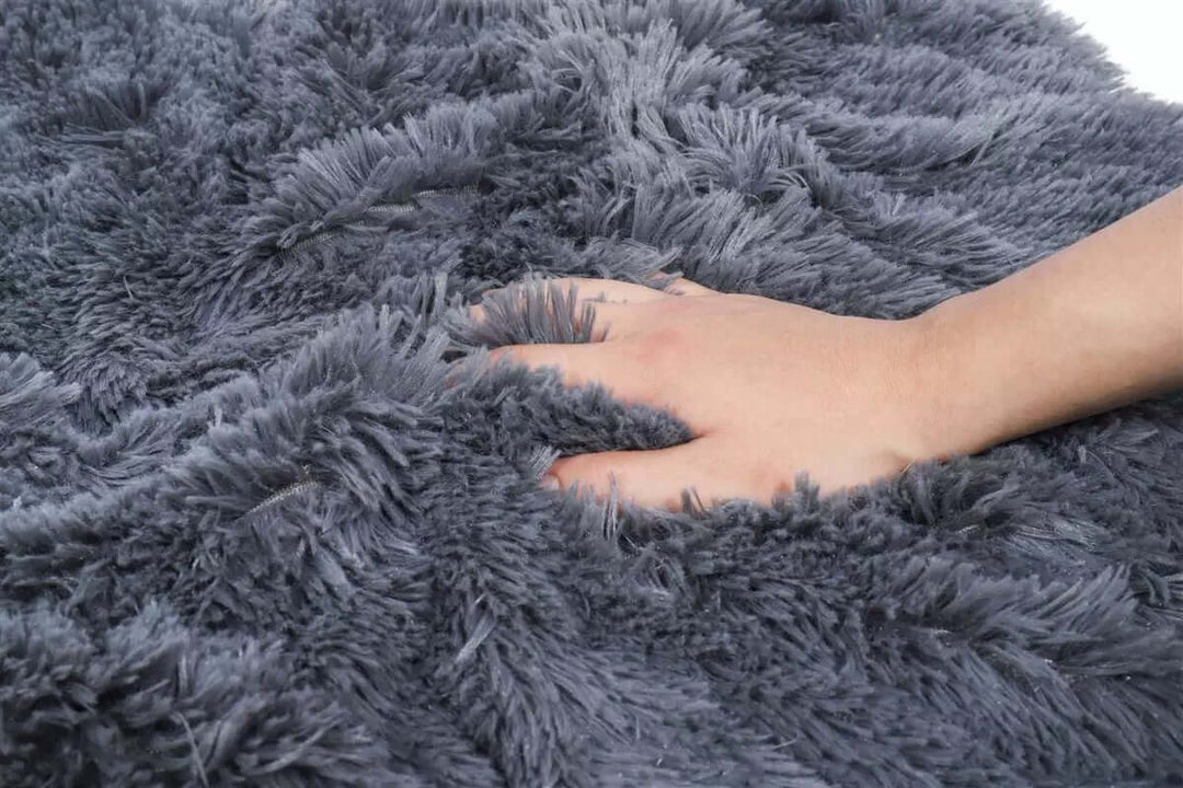 Close-up of a hand resting on a super soft gray calming plush blanket for pets, showcasing its luxurious and cozy texture.