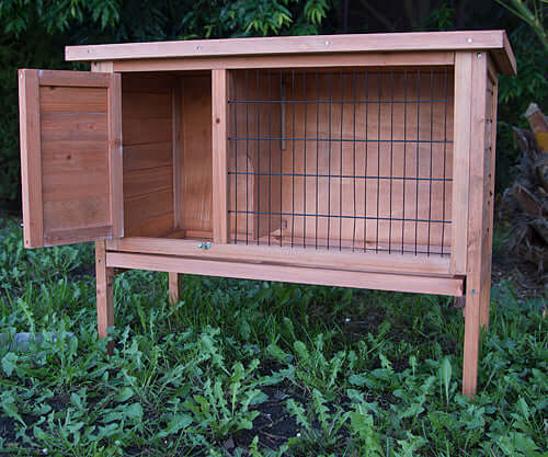 Affordable wooden rabbit hutch with slide-out tray, ideal for guinea pigs and small pets, featuring a spacious design.