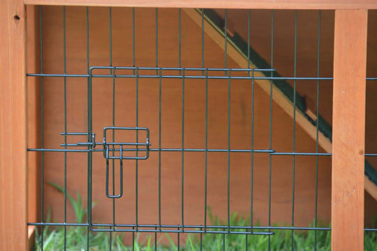 Close-up of the access gate on a double storey rabbit hutch, featuring a secure latch and metal wire.