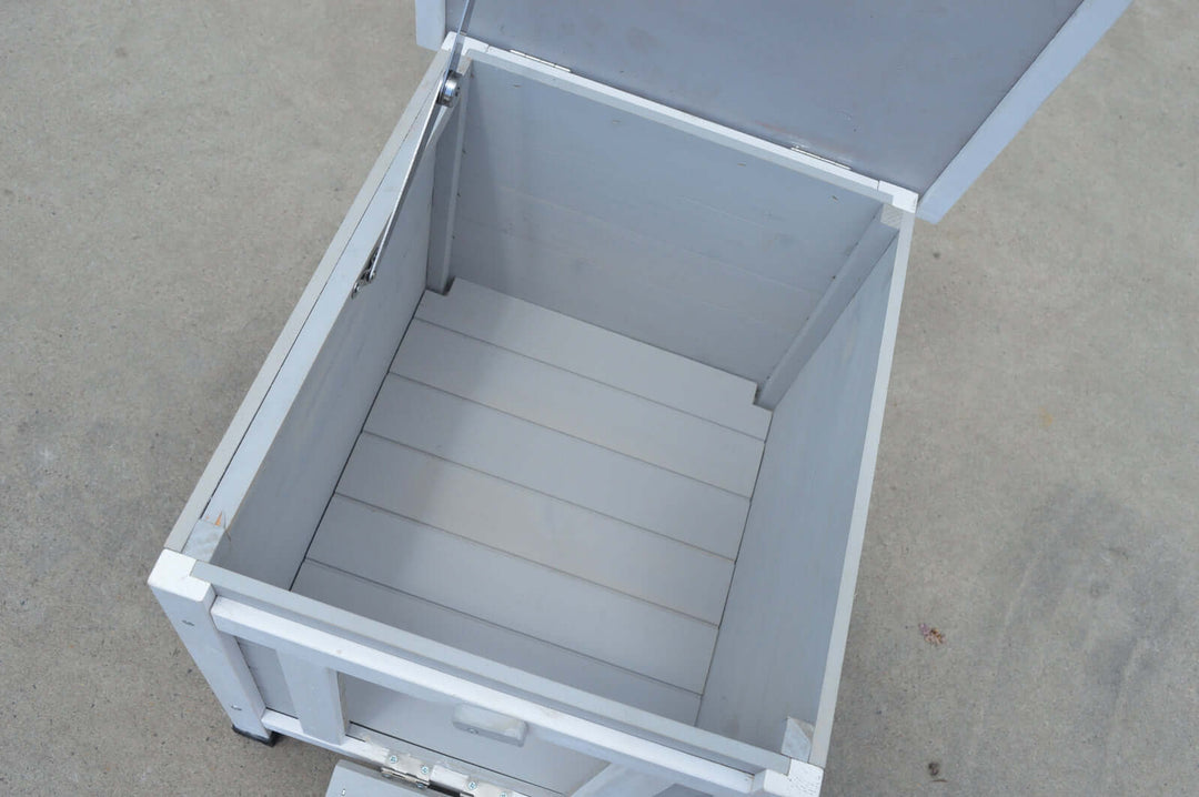 Interior of a grey wooden nesting box with slatted floor and lid open, suitable for small animals.