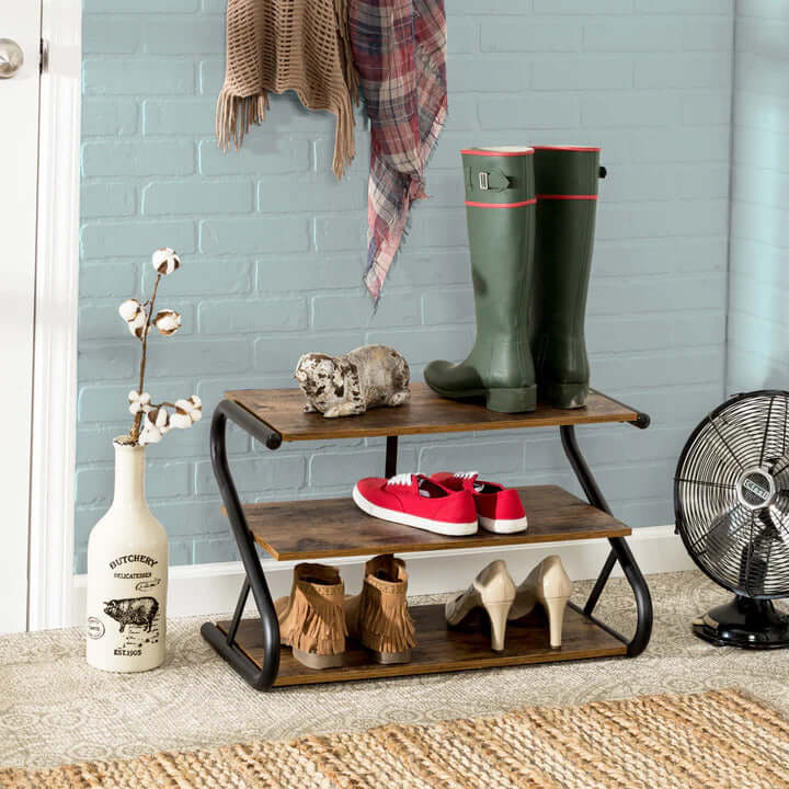 Affordable matte black frame rustic wood 3-tier shoe rack with stylish boots and sneakers in a cozy entryway setting.