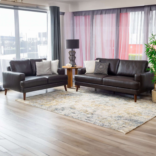 Chocolate leather 3+2 seater sofa set in modern lounge, featuring decorative cushions and stylish decor elements.