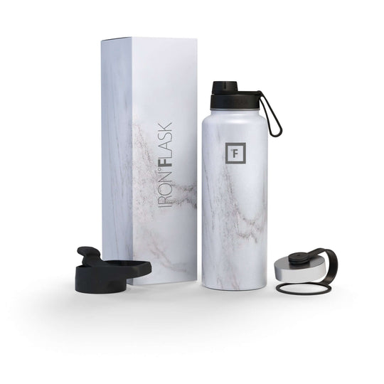 Iron Flask 40oz bottle with spout lid in Carrara Marble design, alongside its packaging and lids. Affordable luxury for hydration.