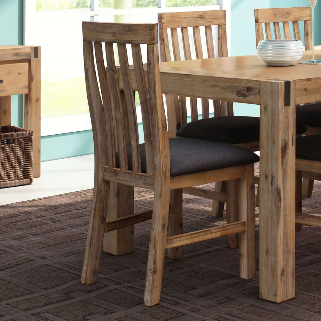 2x Wooden Frame Leatherette Dining Chairs in Acacia Timber Oak Colour around a matching dining table in a bright dining room