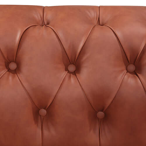 Close-up of button tufted faux leather on a brown sofa, showcasing luxurious and quality upholstery details.