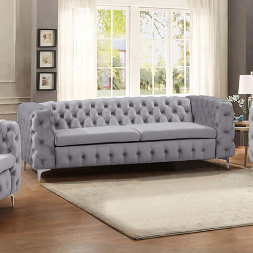 Stylish 3 seater grey velvet sofa with classic button tufting and metal legs in a modern living room setting.