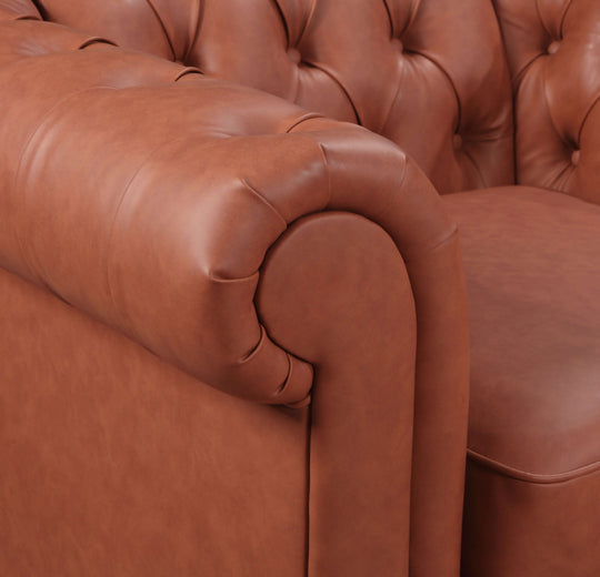 Close-up of a button-tufted brown faux leather sofa showcasing luxurious cushioning and curved arm design.