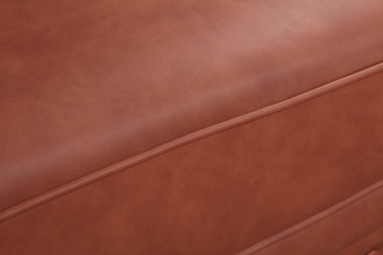 Close-up of luxurious brown faux leather upholstery on a modern sofa, showcasing quality craftsmanship.