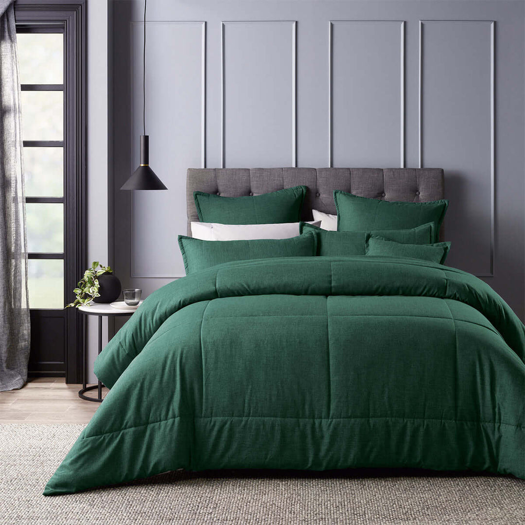 Luxurious green comforter set with pillows and cushion on a stylish bed, perfect for adding affordable elegance to any bedroom.