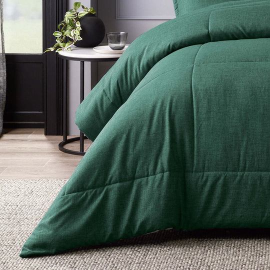 Green quilted comforter on bed, part of Bianca Maynard's 6-piece set, featuring super soft fabric and luxe design.