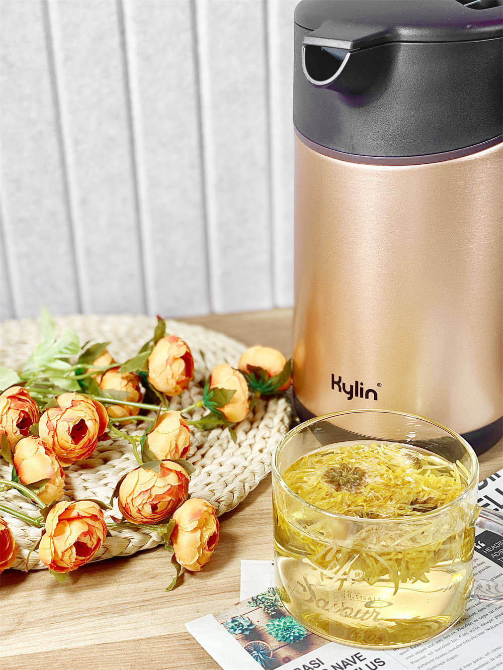 Kylin Vacuum Thermal Insulated Kettle 1.5L with floral arrangement and herbal tea in a glass on a wooden table.