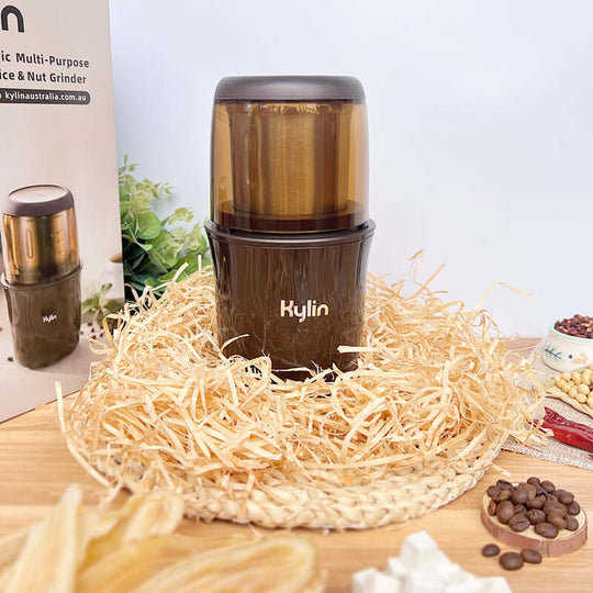 Kylin Electric Multi-Purpose Coffee, Spice & Nut Grinder on a bed of straw, showcasing its sleek design and quality materials.