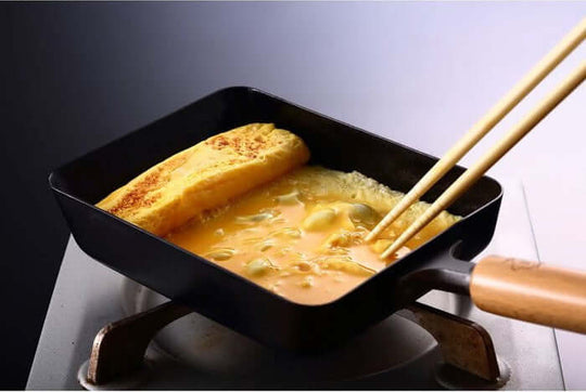 Cooking a fluffy omelet in a TAKUMI Tamagoyaki small fry pan, showcasing affordable quality and DIY culinary excellence.