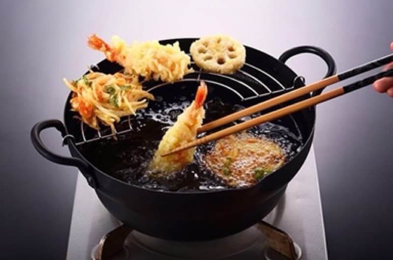 Deep frying tempura in a Takumi Japan iron pot, showcasing rich textures and delicious ingredients. Affordable quality cookware.