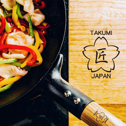 Takumi Premium Magma Plate Cast Iron Wok with colorful stir-fried vegetables, showcasing craftsmanship from Japan.