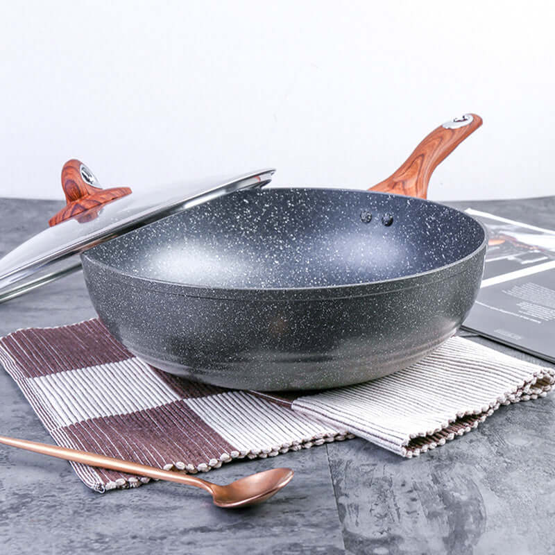 Justcook 30cm marble wok stir-fry pan on a table with a lid and a wooden handle, showcasing its non-stick surface.