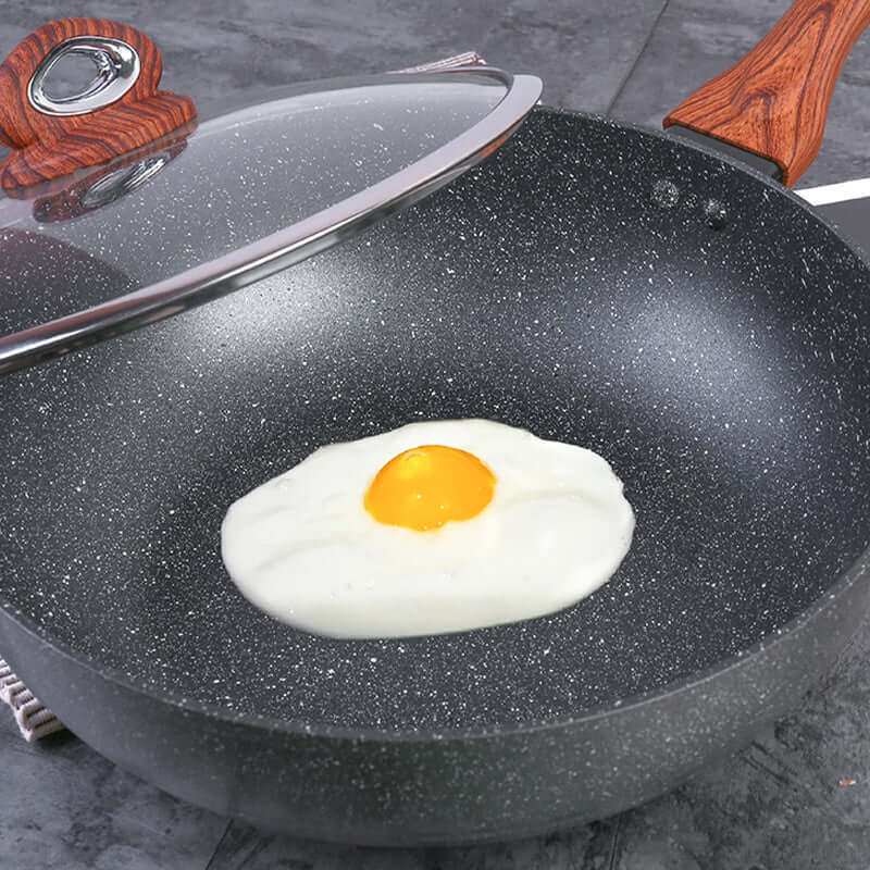 Justcook 30cm marble wok frying an egg, showcasing non-stick surface and elegant design.