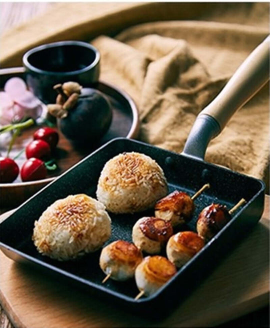 Stylish non-stick square pan with rice balls and skewered snacks, showcasing quality cooking experience and modern kitchen aesthetics.