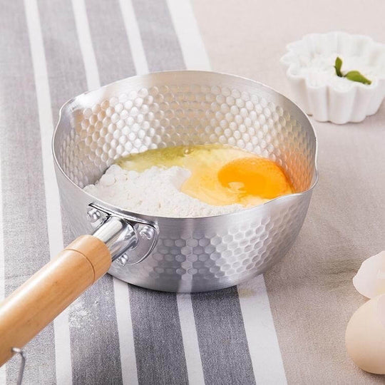 Justcook 20cm Japanese-style stainless steel pot with egg and flour mixture, featuring a wooden handle on a striped cloth.