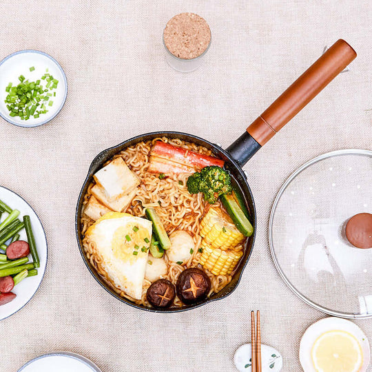 Justcook 20cm Xueping Pot filled with ramen, vegetables, and tofu, showcasing its ergonomic wooden handle and stylish design.