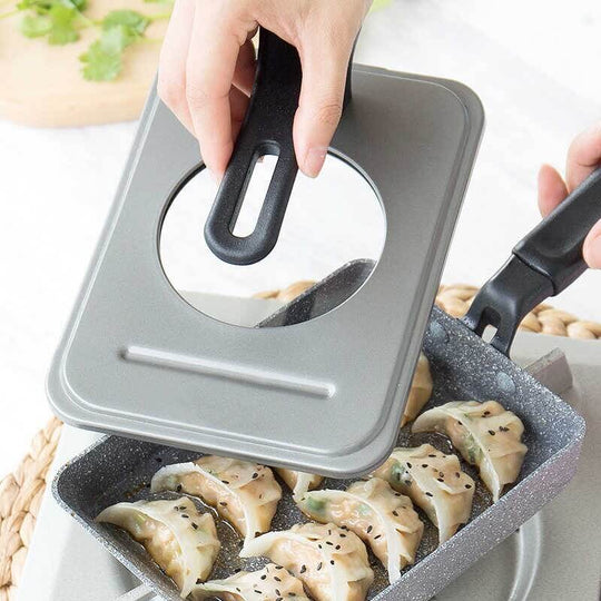 Justcook grey tamago fry pan lid being lifted to reveal dumplings, showcasing quality and affordable DIY cooking.