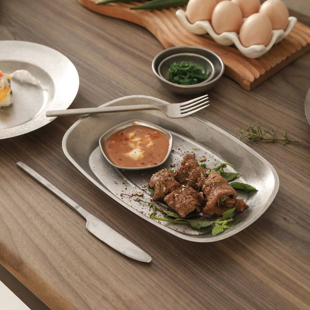 Stylish Kylin stainless steel fork on a rustic table with delicious steak, sauce, and eggs in the background.